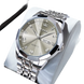 Montre à quartz pour homme, de couleur argentée, avec affichage de la date du jour, lunette à facettes multiples, index en chiffres romains et en diamants, et bracelet à maillons en métal.